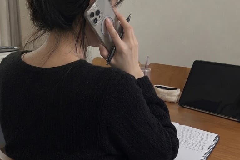 Ellie au téléphone avec un restaurant, carnet de vérification ouvert